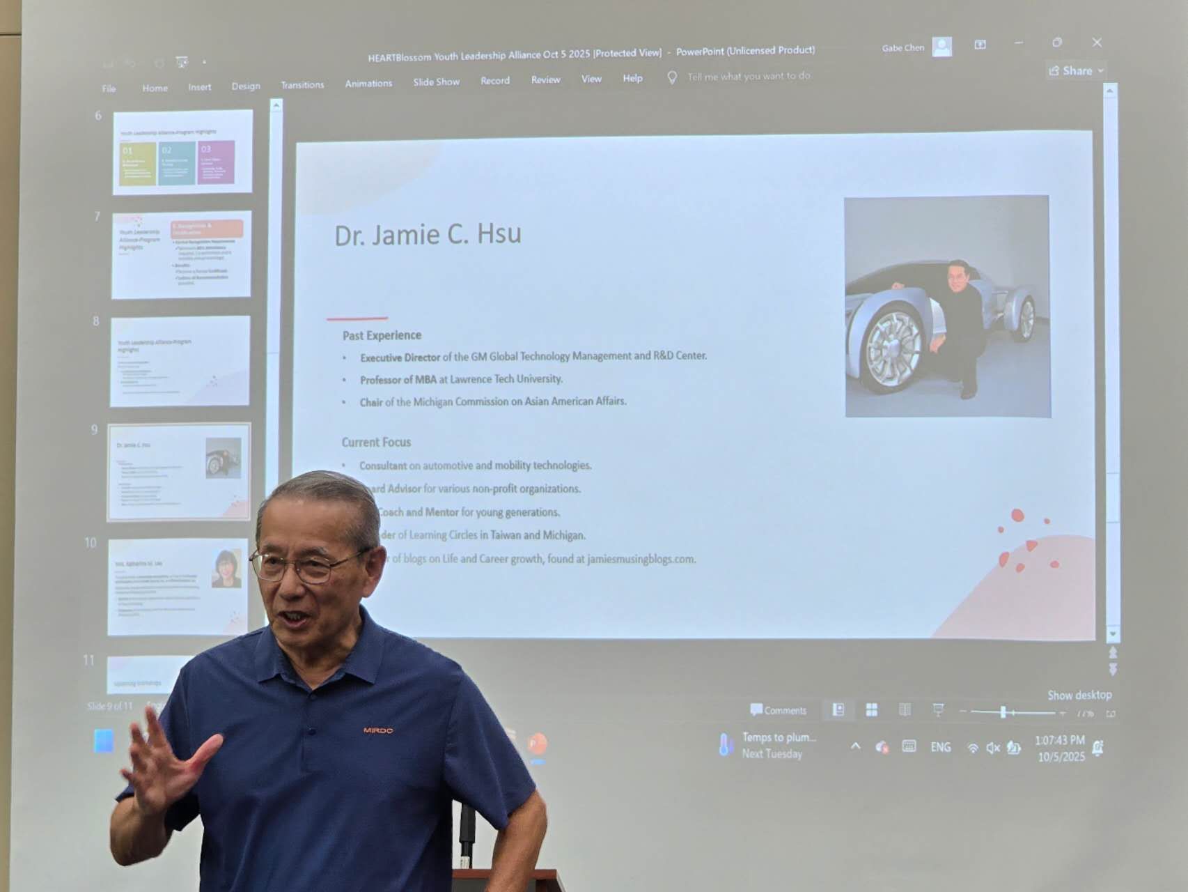 Man giving a presentation in front of a screen with slides; includes text and a photo.