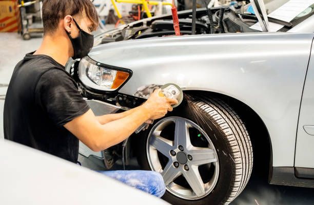 A Man Wearing A Mask Is Polishing The Fender Of A Car - Dover, NJ - Roger Coss Auto Body