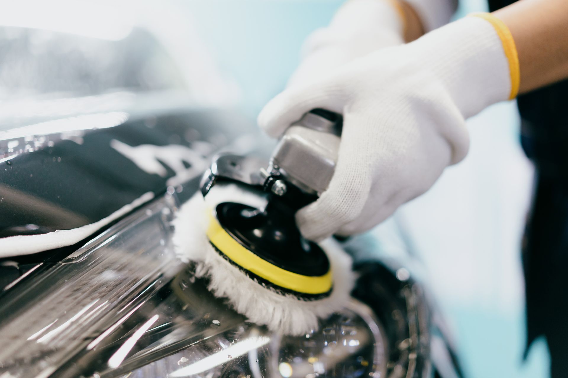 A Person Is Polishing The Headlight Of A Car With A Polisher - Dover, NJ - Roger Coss Auto Body