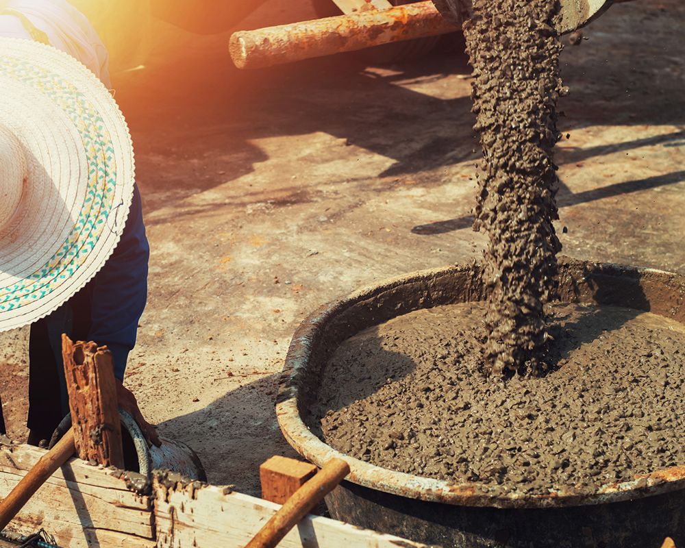 A worker pouring concrete mix for sale in Carolina Beach, NC, from Southport Concrete Corp. for building construction.