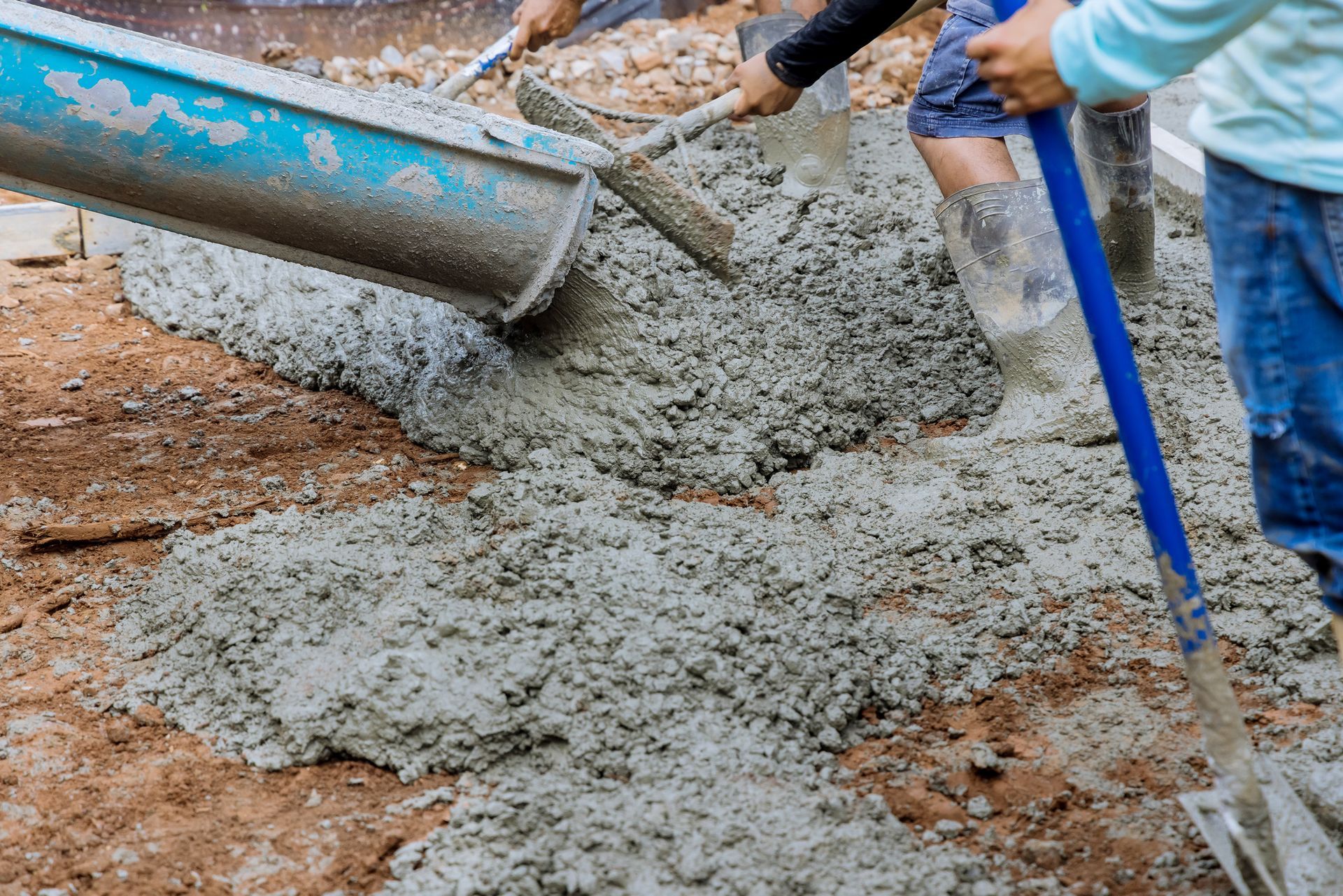 Construction workers pouring ready-mix concrete on-site for a durable building foundation.