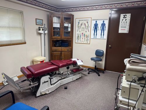 A doctor's office with a red table and a blue chair.