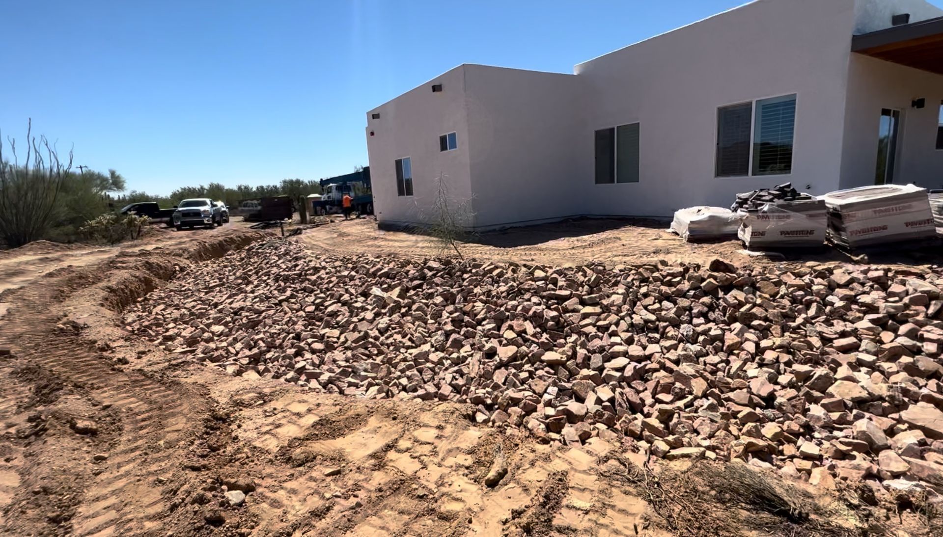 A white house is sitting on top of a dirt hill.