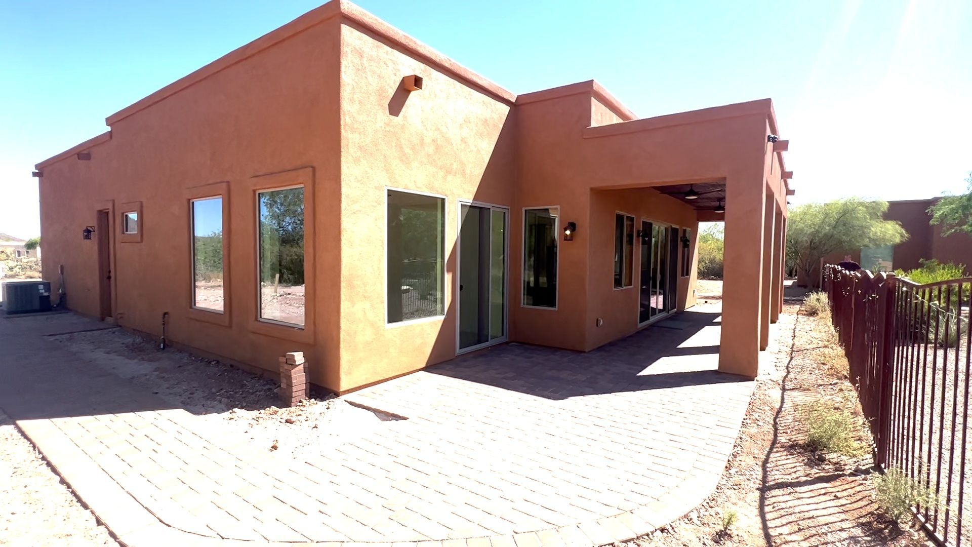 A house with a lot of windows and a fence in front of it