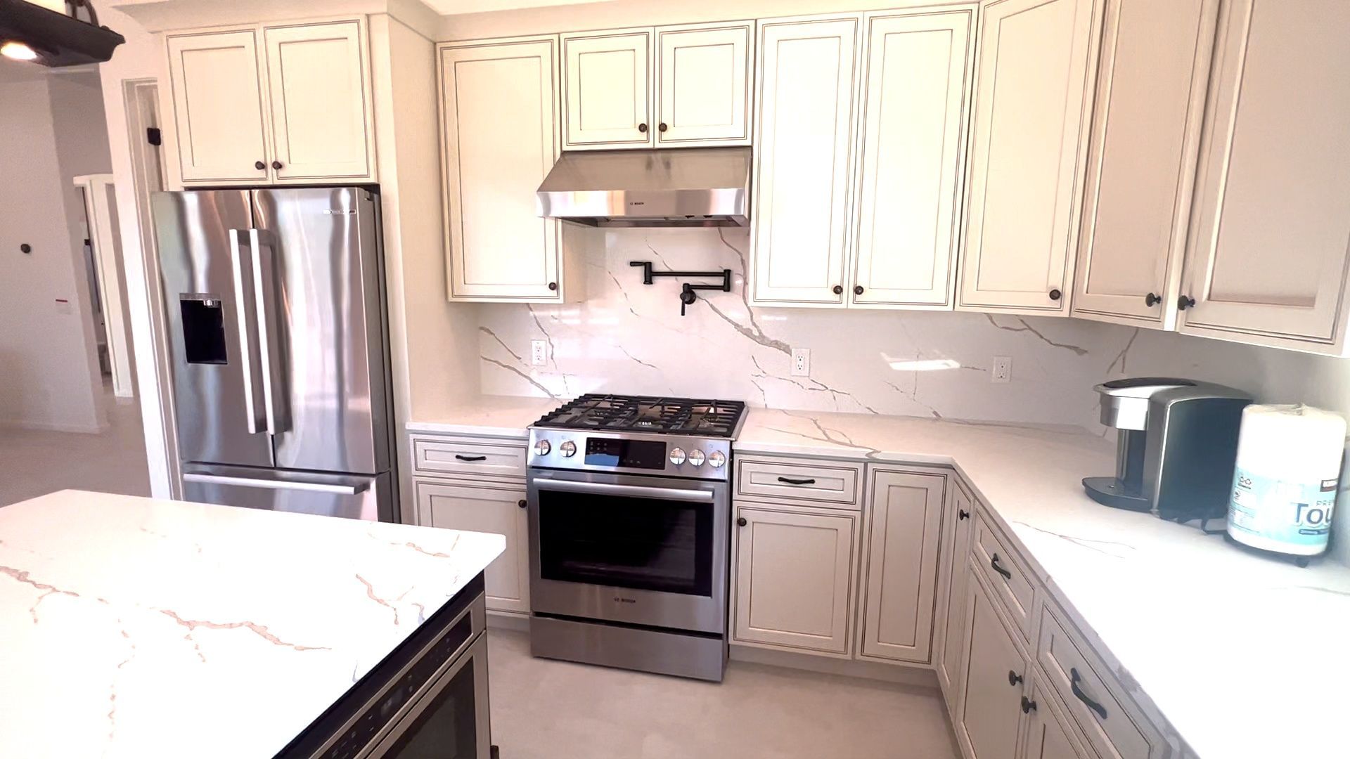 A kitchen with white cabinets and stainless steel appliances.