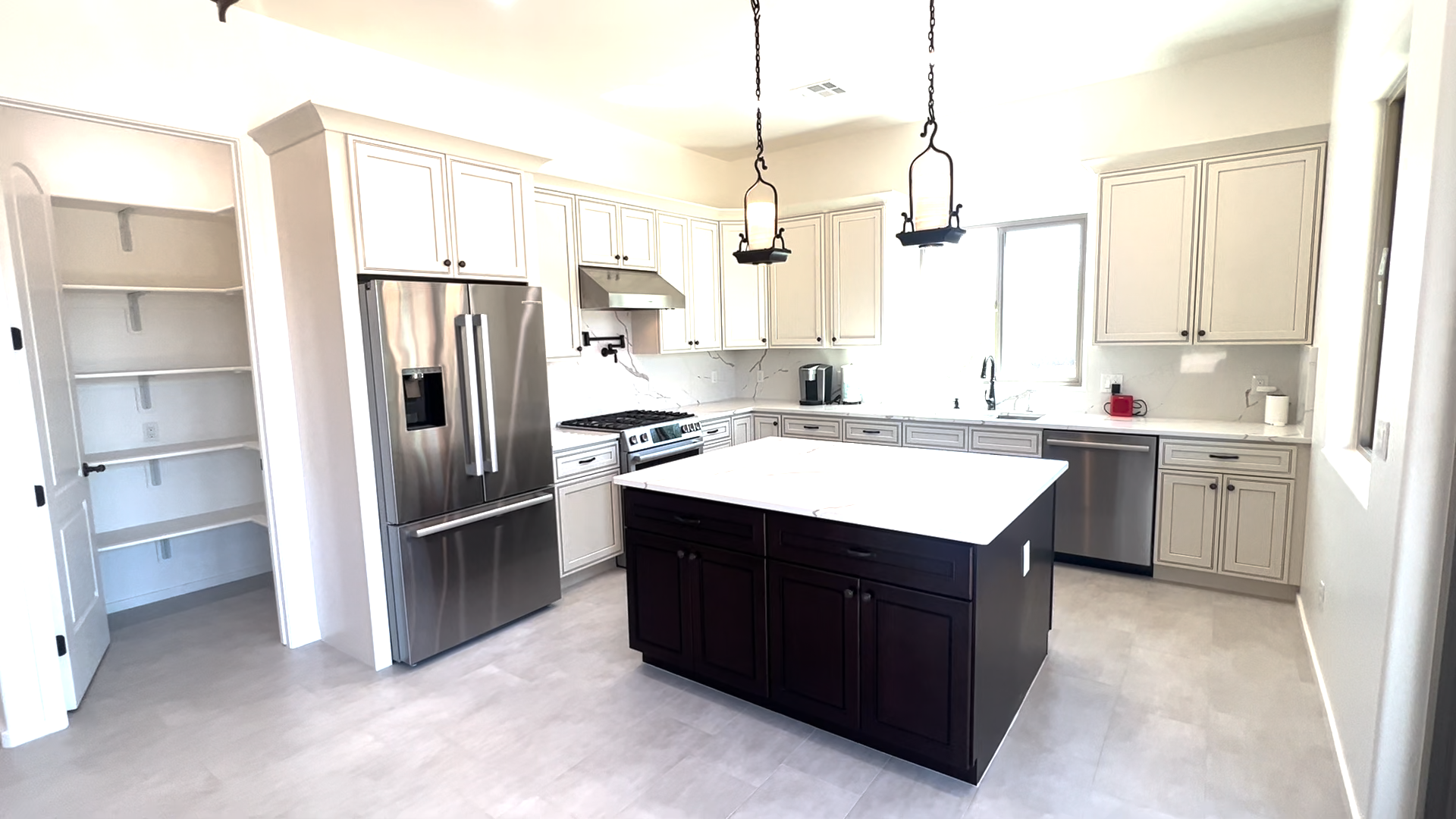 A kitchen with stainless steel appliances and a large island in the middle.