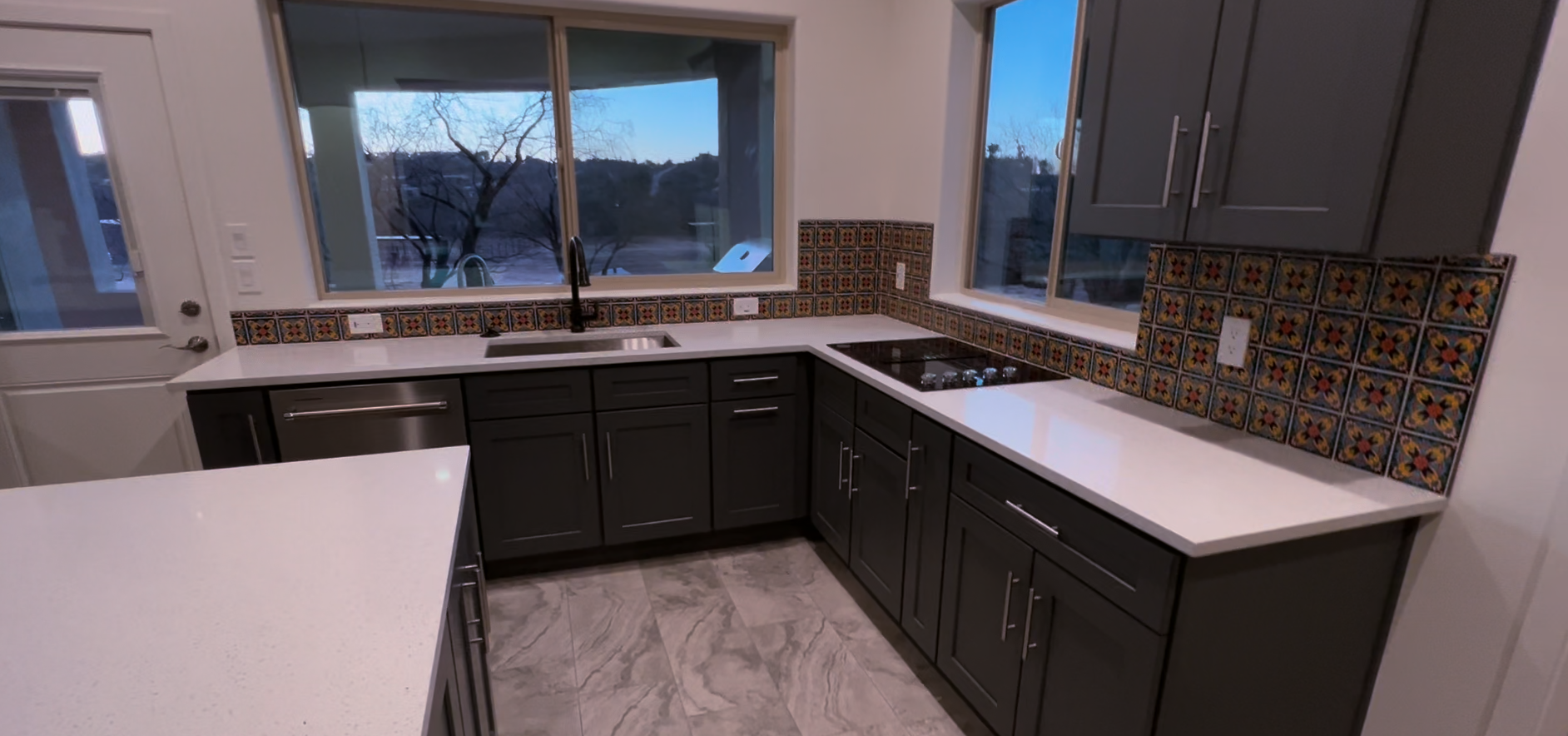 A recently remodeled kicteh with a sink and induction stovetop