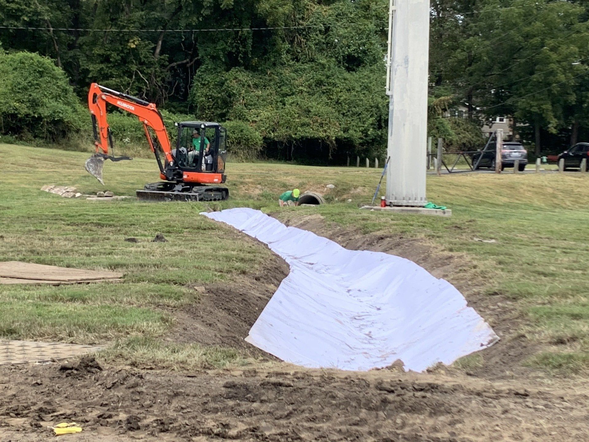 An excavator is digging a hole in the ground in a field.