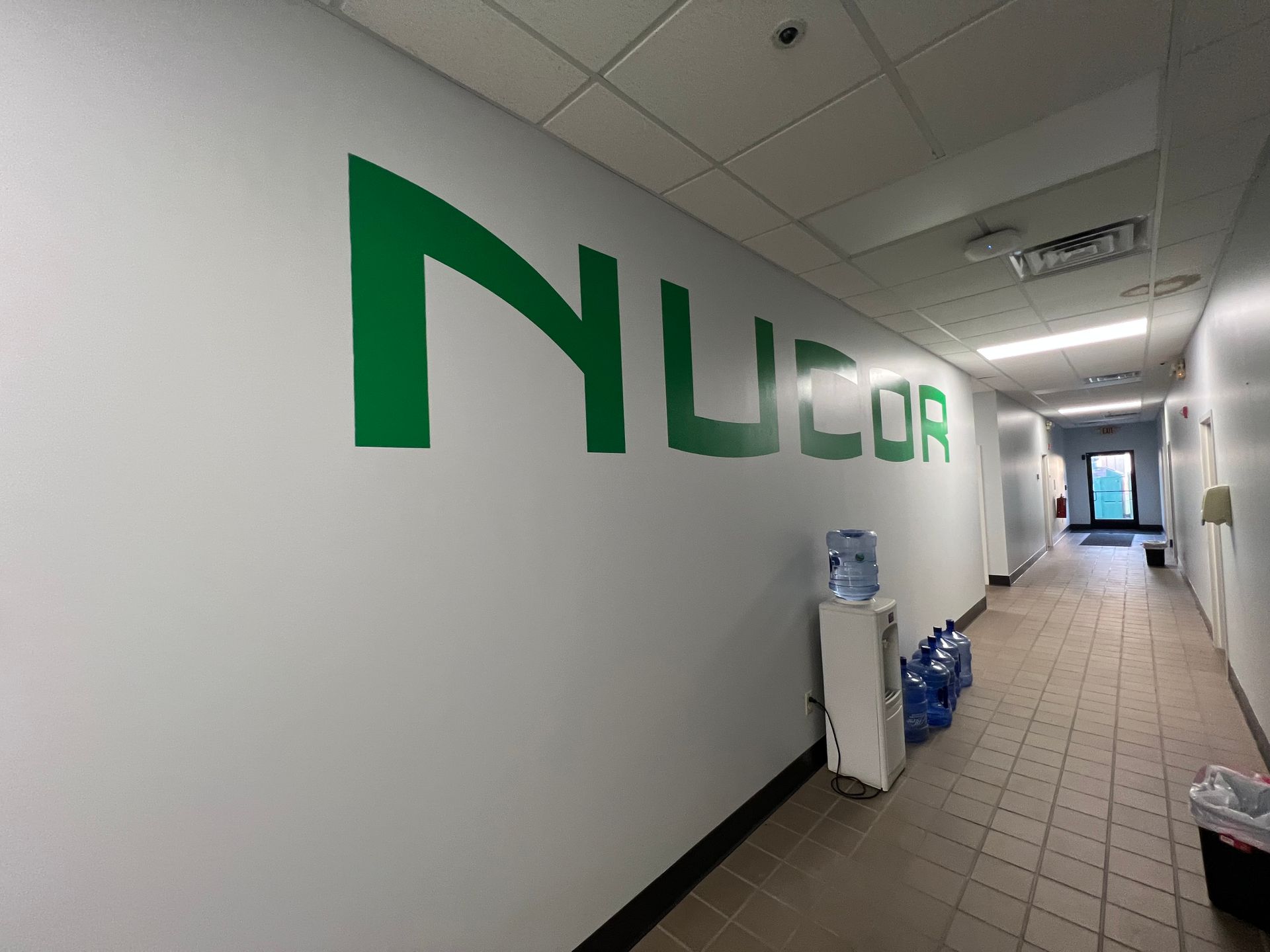 A paint roller is sitting on top of a bucket of paint.