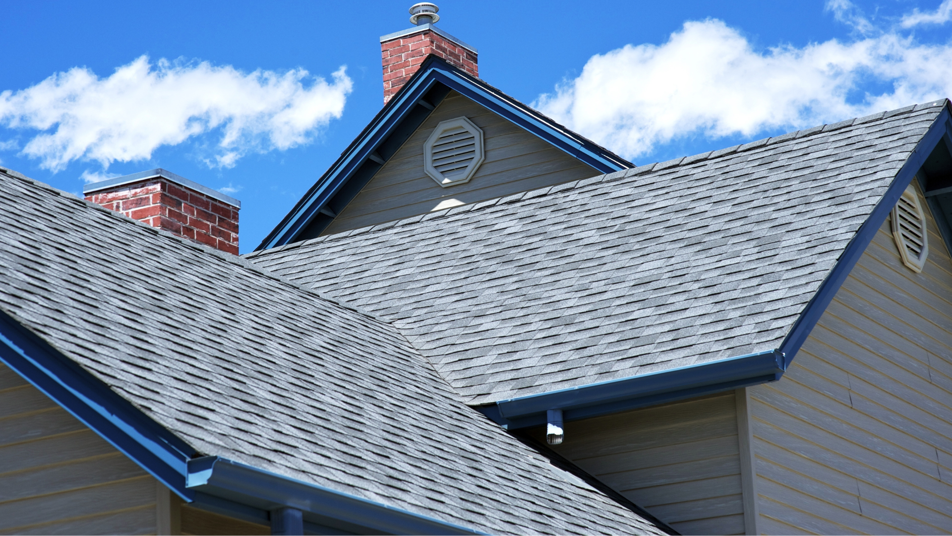 A house with a gray roof and a chimney on top of it.