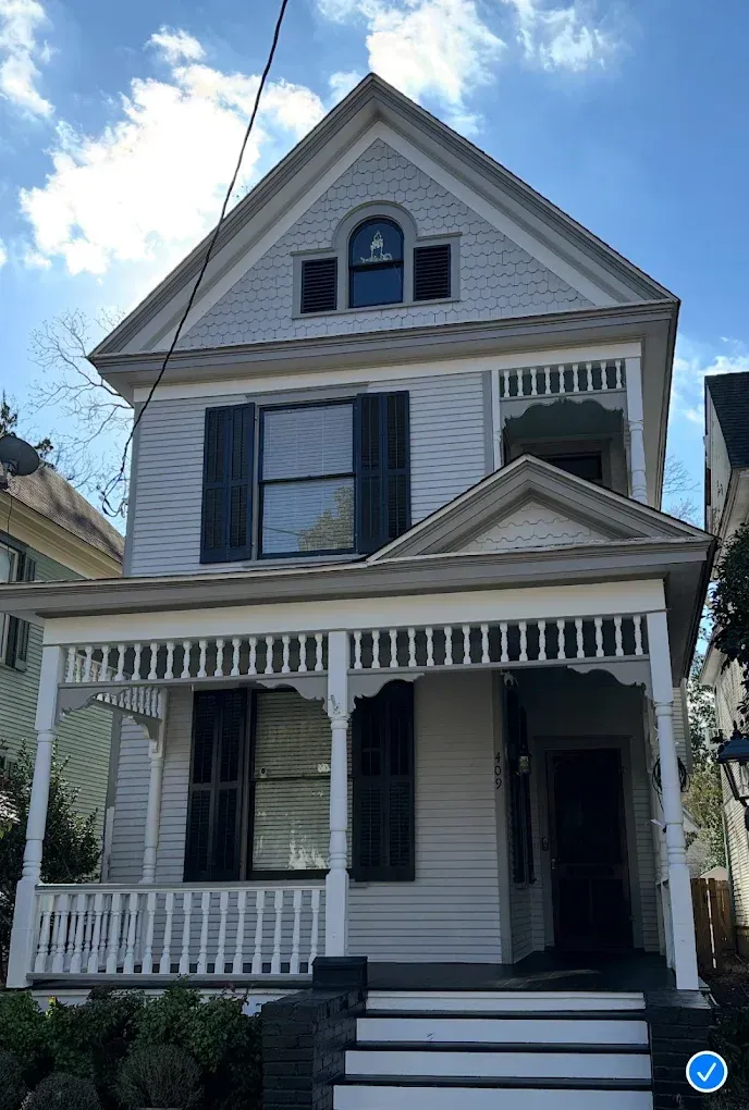 A white house with black shutters and a porch