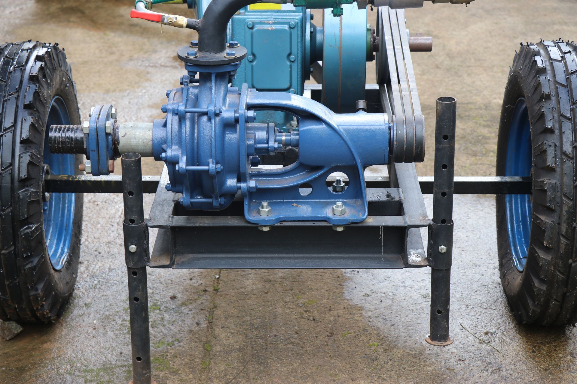 Industrial water pump mounted on a metal frame with two wheels and belts.