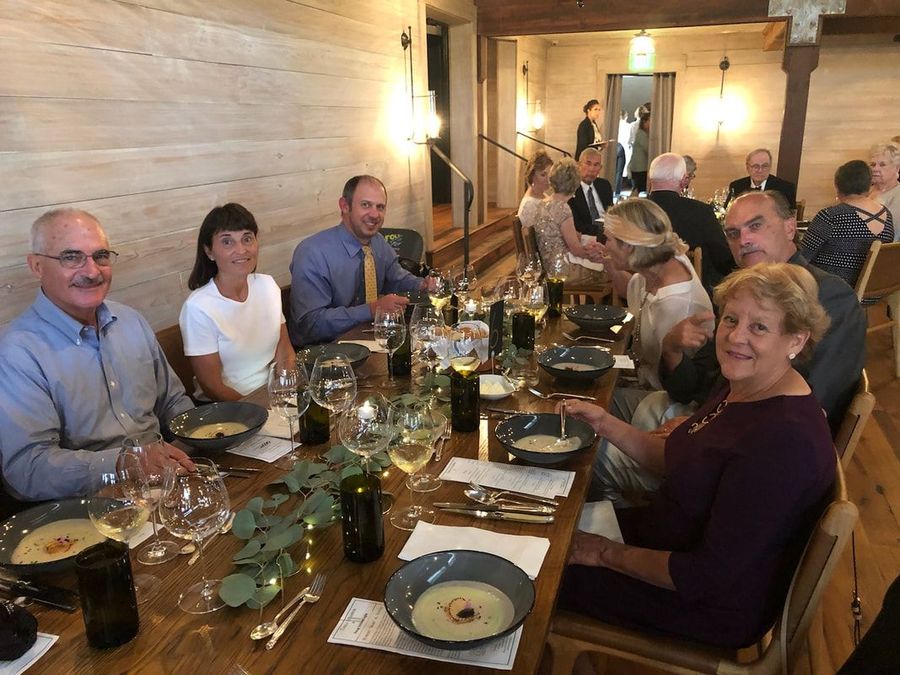 A group of people are sitting at a long table eating food.