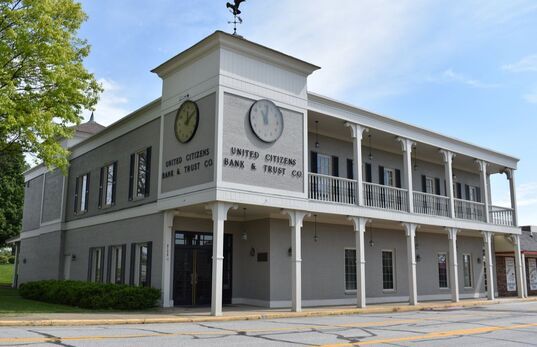A large white building with a clock on the side of it.