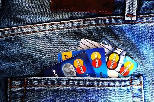 A stack of credit cards in the back pocket of a pair of jeans