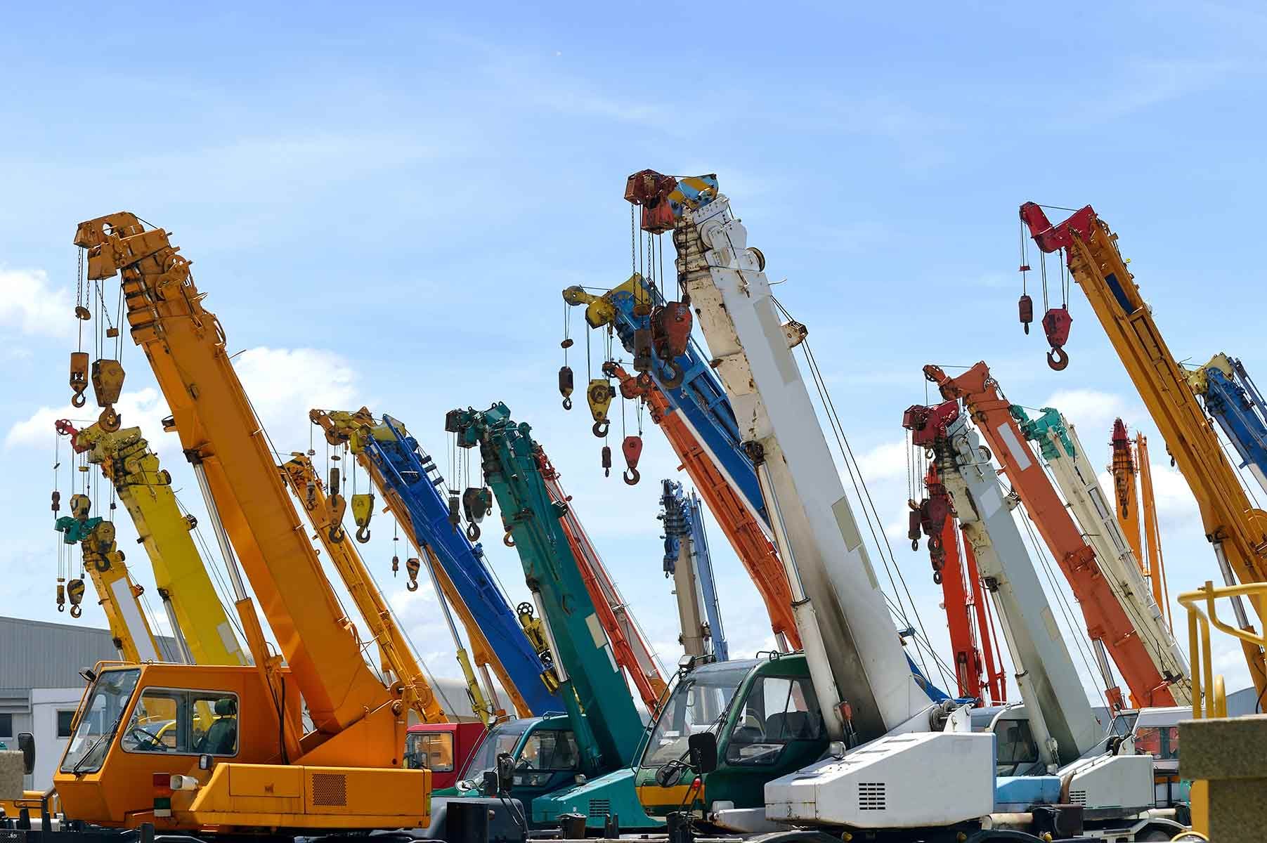 A Bunch Of Colourful Cranes Are Parked In A Lot — Gympie Crane Hire In Glanmire, QLD