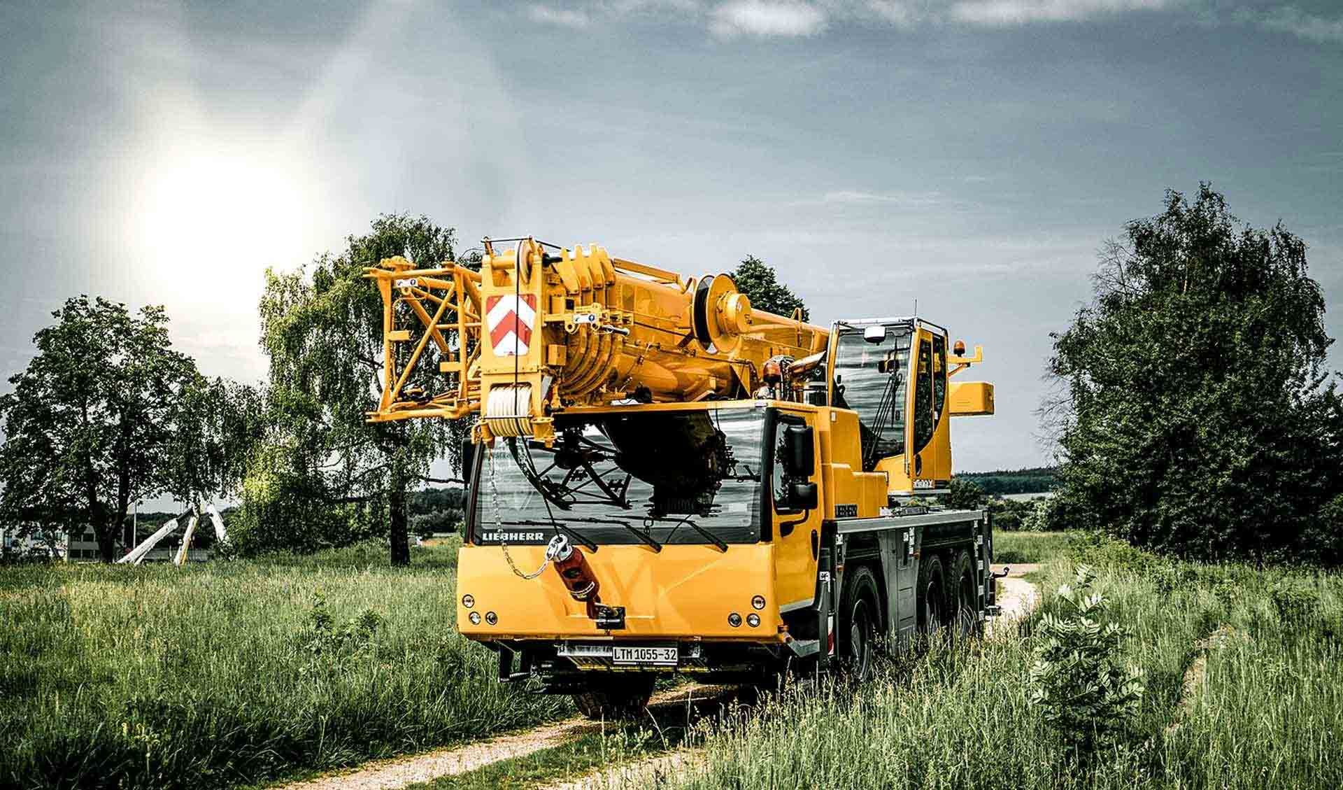 A Yellow Crane Is Parked On The Side Of A Dirt Road In A Field — Gympie Crane Hire In Glanmire, QLD