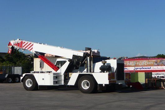 A Crane Is Parked In A Parking Lot Next To A Sign That Says Grand Opening — Gympie Crane Hire In Glanmire, QLD