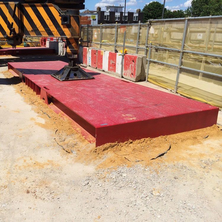 A Red Platform Is Sitting In The Dirt Next To A Yellow And Black Crane — Gympie Crane Hire In Glanmire, QLD