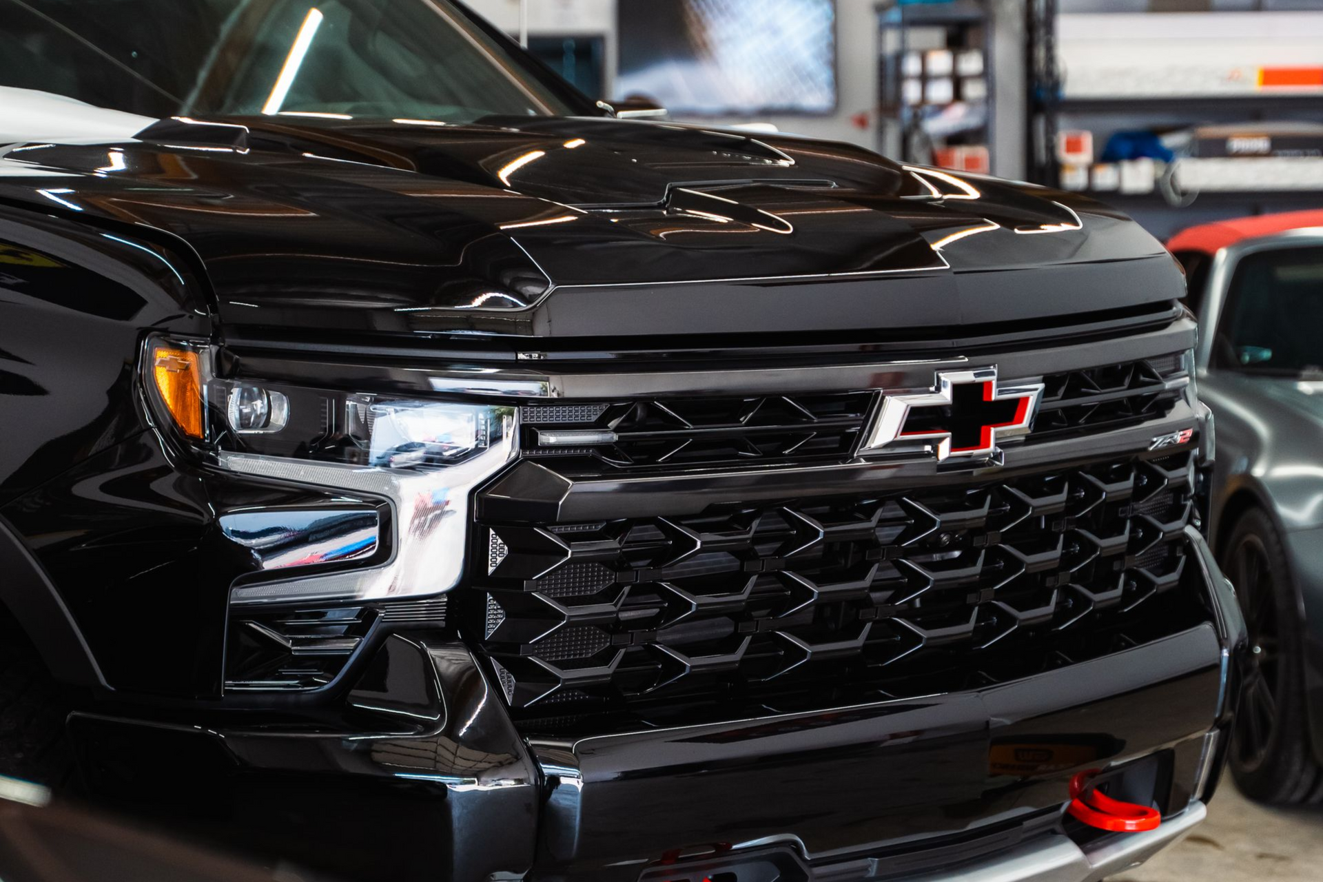 Black Chevrolet truck front grille with red bowtie logo.
