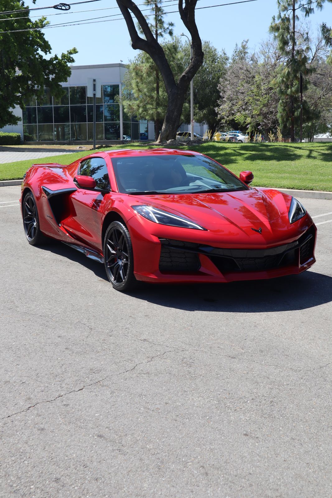 A red sports car is parked in a parking lot.