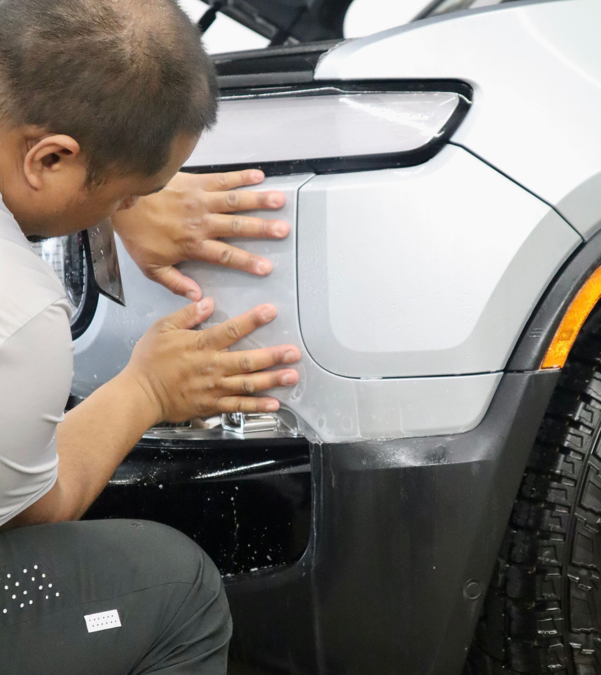 A man is working on the front of a car