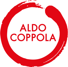 Logo circolare rosso di Aldo Coppola con testo bianco.