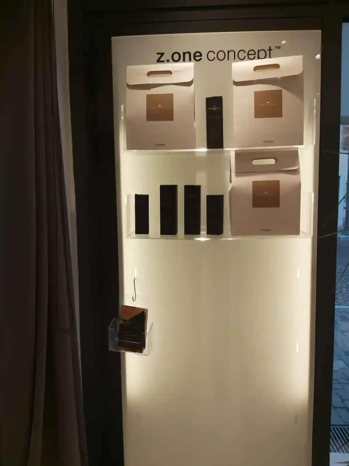 Capelli biondi ondulati e mèches di una donna, pettinati di lato e tenuti in mano; ambientazione da salone di bellezza.