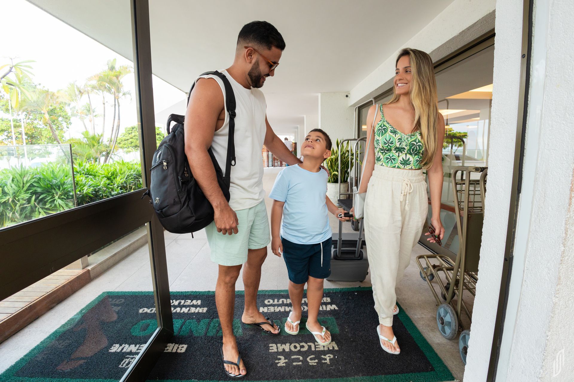 Família, com pai, mãe e filho entrando na recepção do Hotel Ponta Verde Maceió.