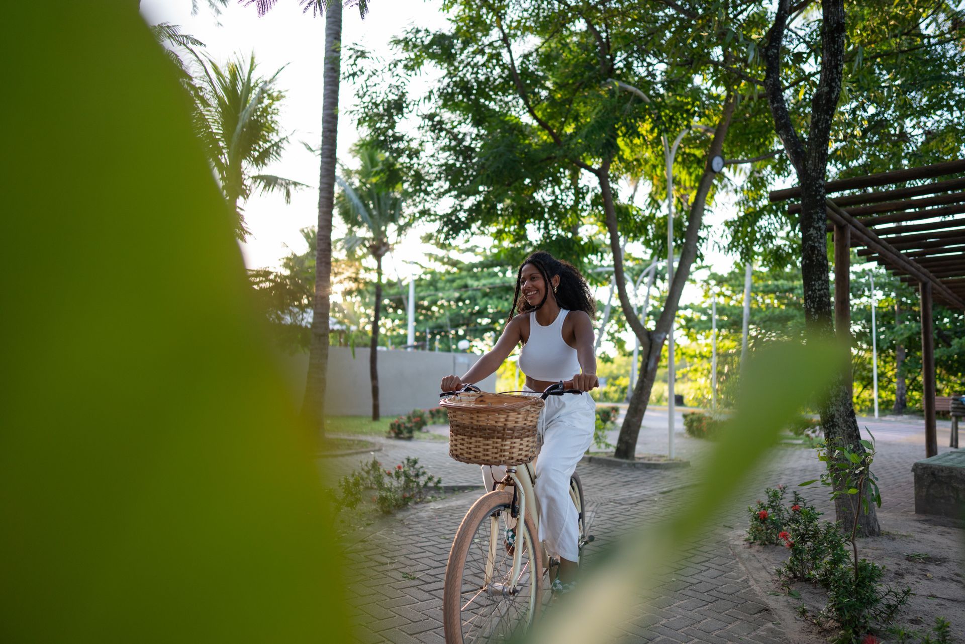 Foto de uma mulher andando de bicicleta no corredor verde da praia do francês.