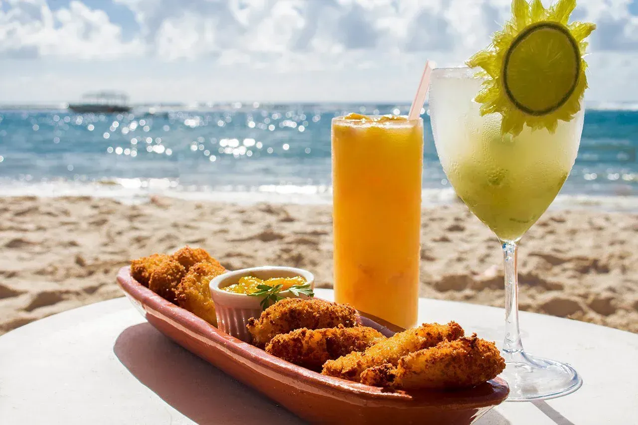 Foto de um drink e petisco do nosso Serviço de Praia Exclusivo.