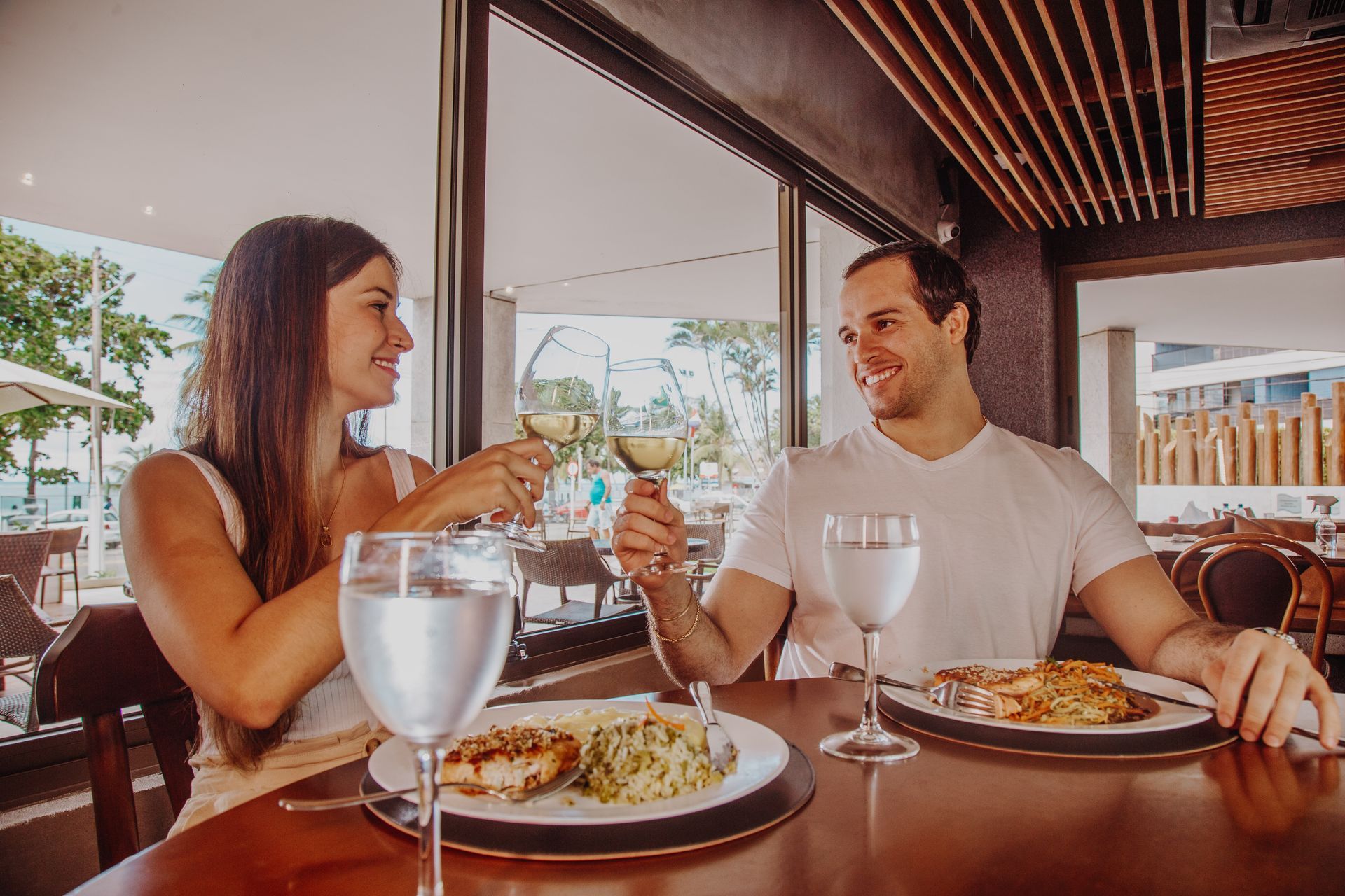 Casal brindando à mesa do Restaurate Dona Ana, do Hotel Ponta Verde Maceió!