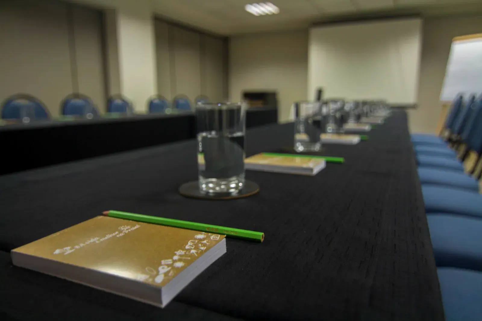 Uma sala de conferências com uma mesa longa e cadeiras preparadas para uma reunião.