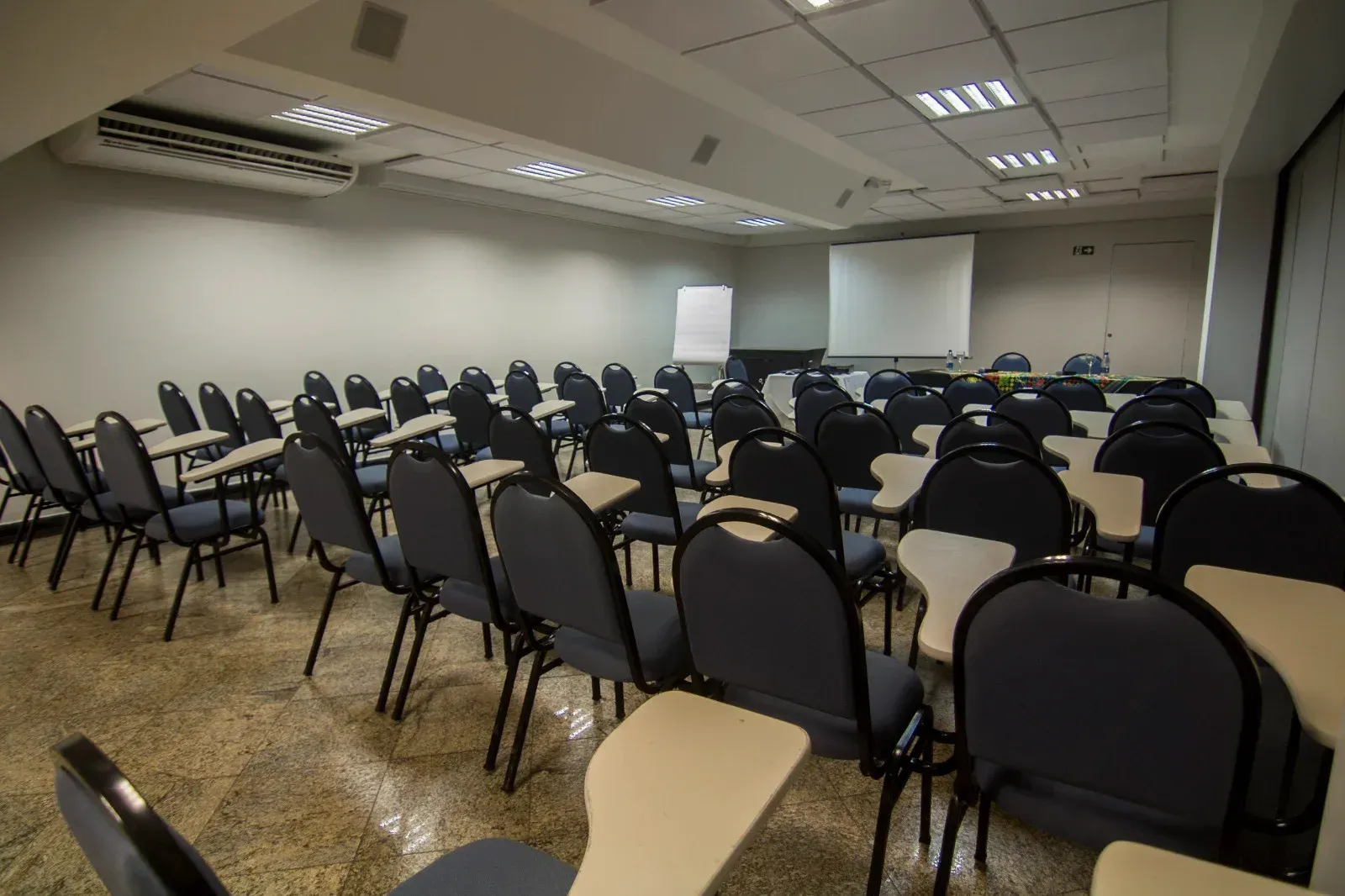 Uma sala de conferências com fileiras de cadeiras e mesas