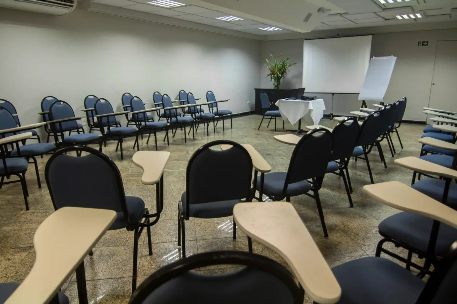 Uma sala de conferências com fileiras de cadeiras e mesas