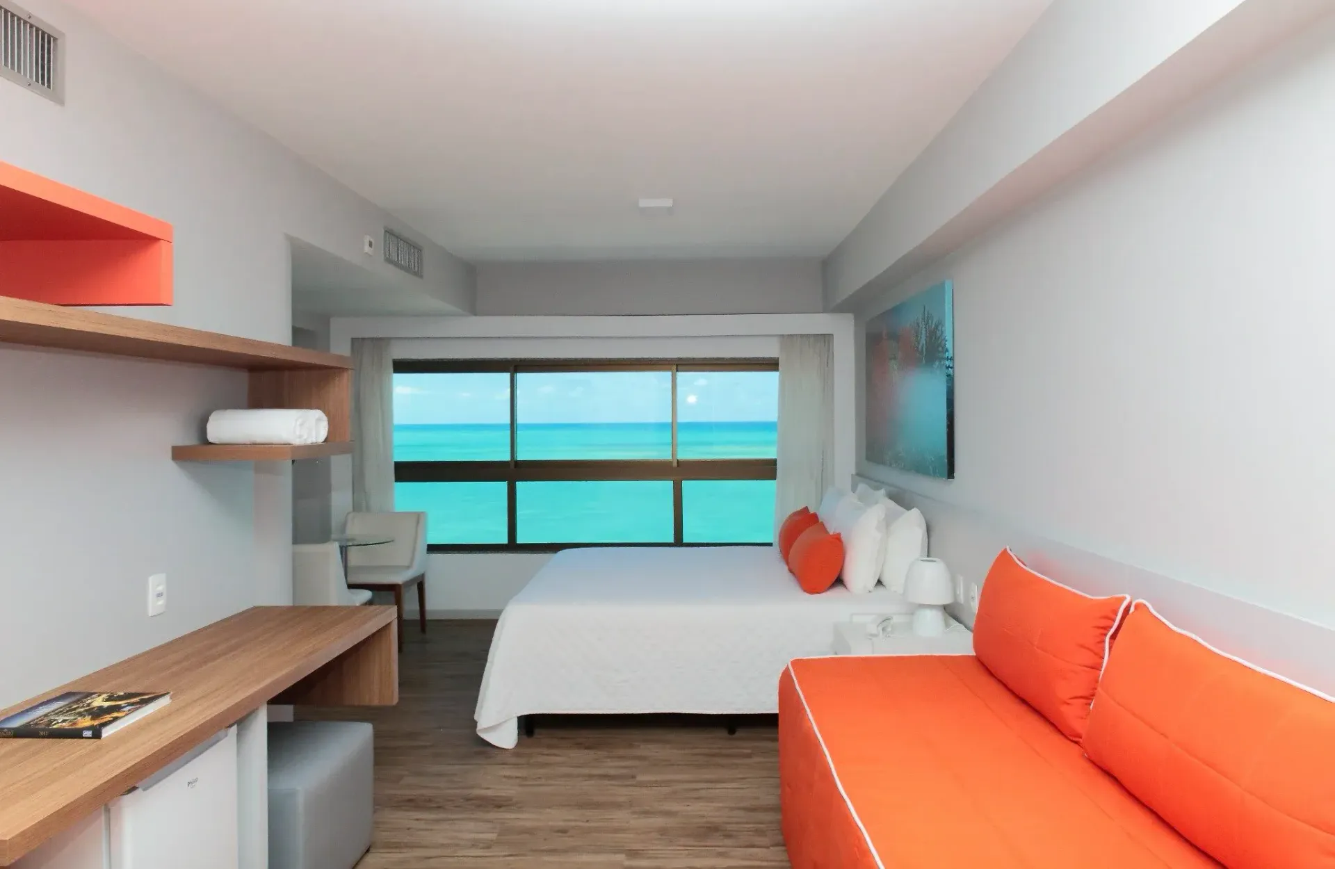 Um quarto de hotel com um sofá e uma cama com vista para o oceano.
