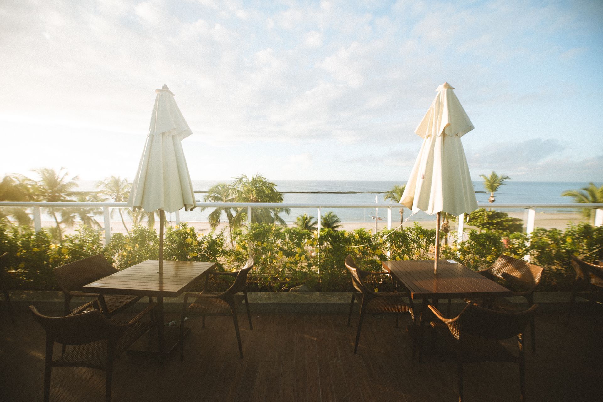 Foto do amanhecer no rooftop do Hotel Ponta Verde Praia do Francês, com o sol iluminando as mesas.