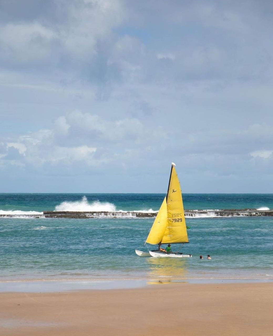 Praia do Francês, um baquinho amarelo em um dia ensolarado.