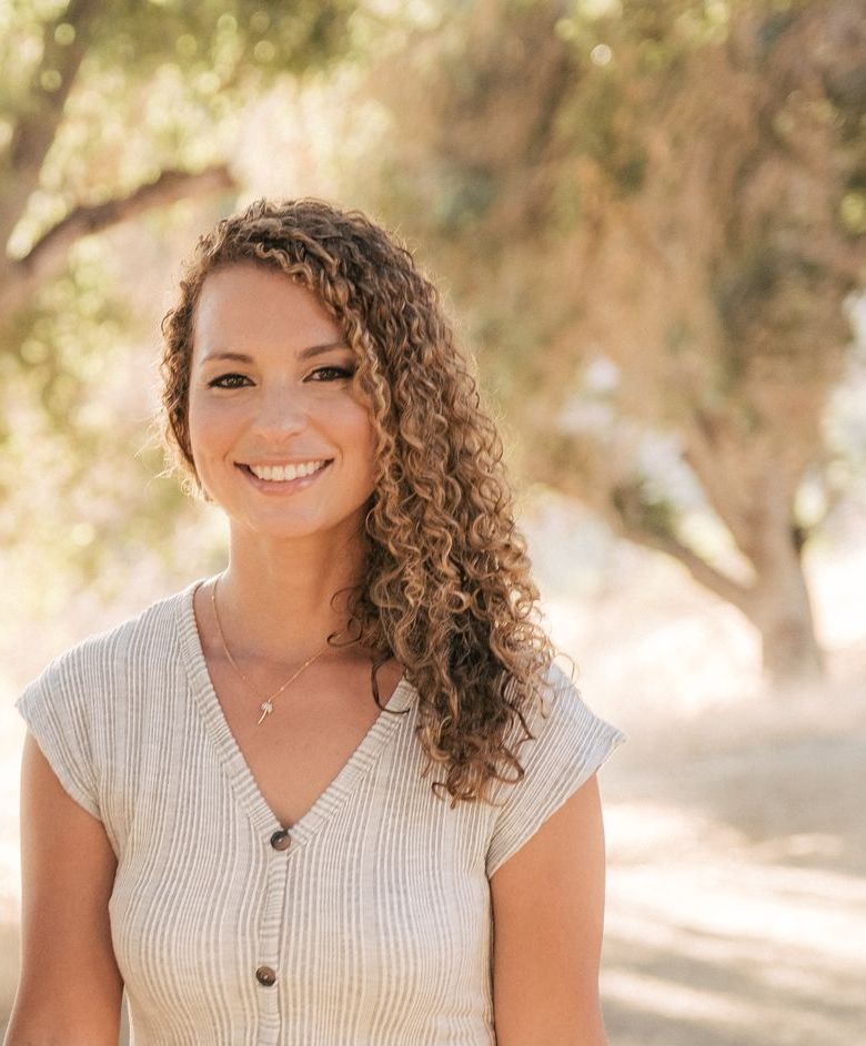 this is sally curran a mental health therapist. She is smiling and has curly hair. 