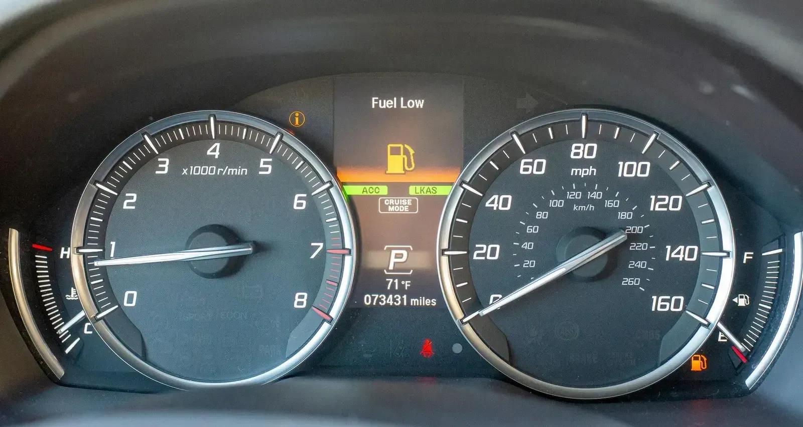 Auto transport carrier loading luxury SUVs at the port terminal with shipping cranes in the background for mainland delivery