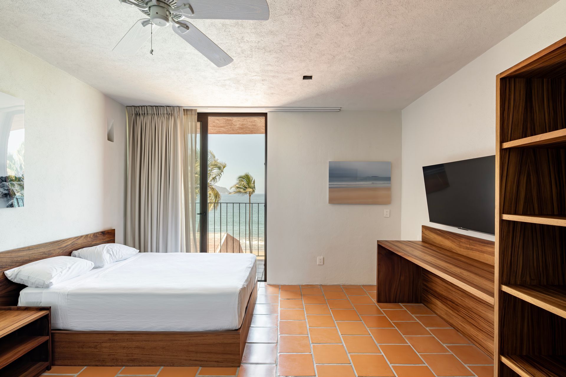 A hotel room with a king size bed and a flat screen tv.