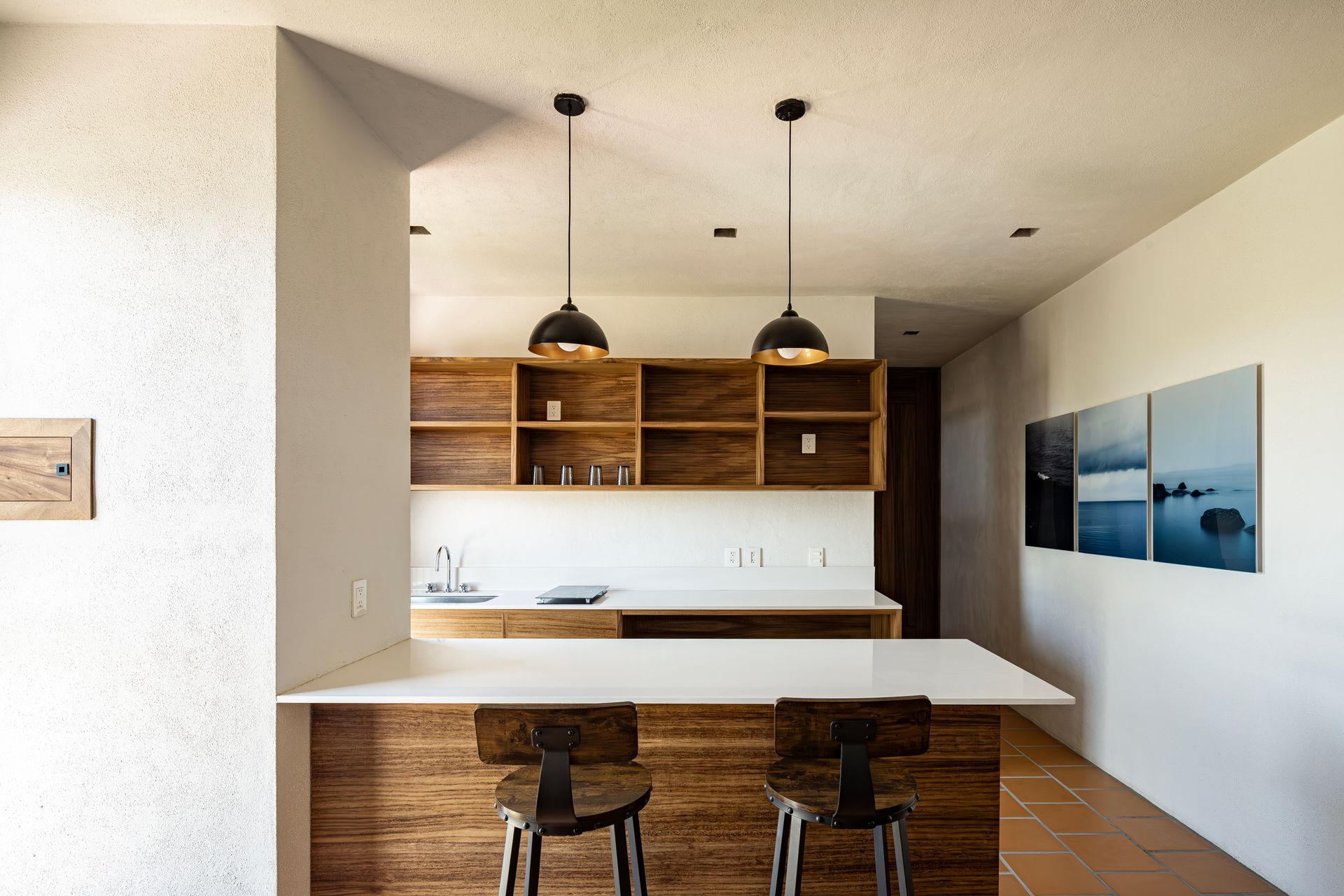 A kitchen with a wooden counter top and two stools.