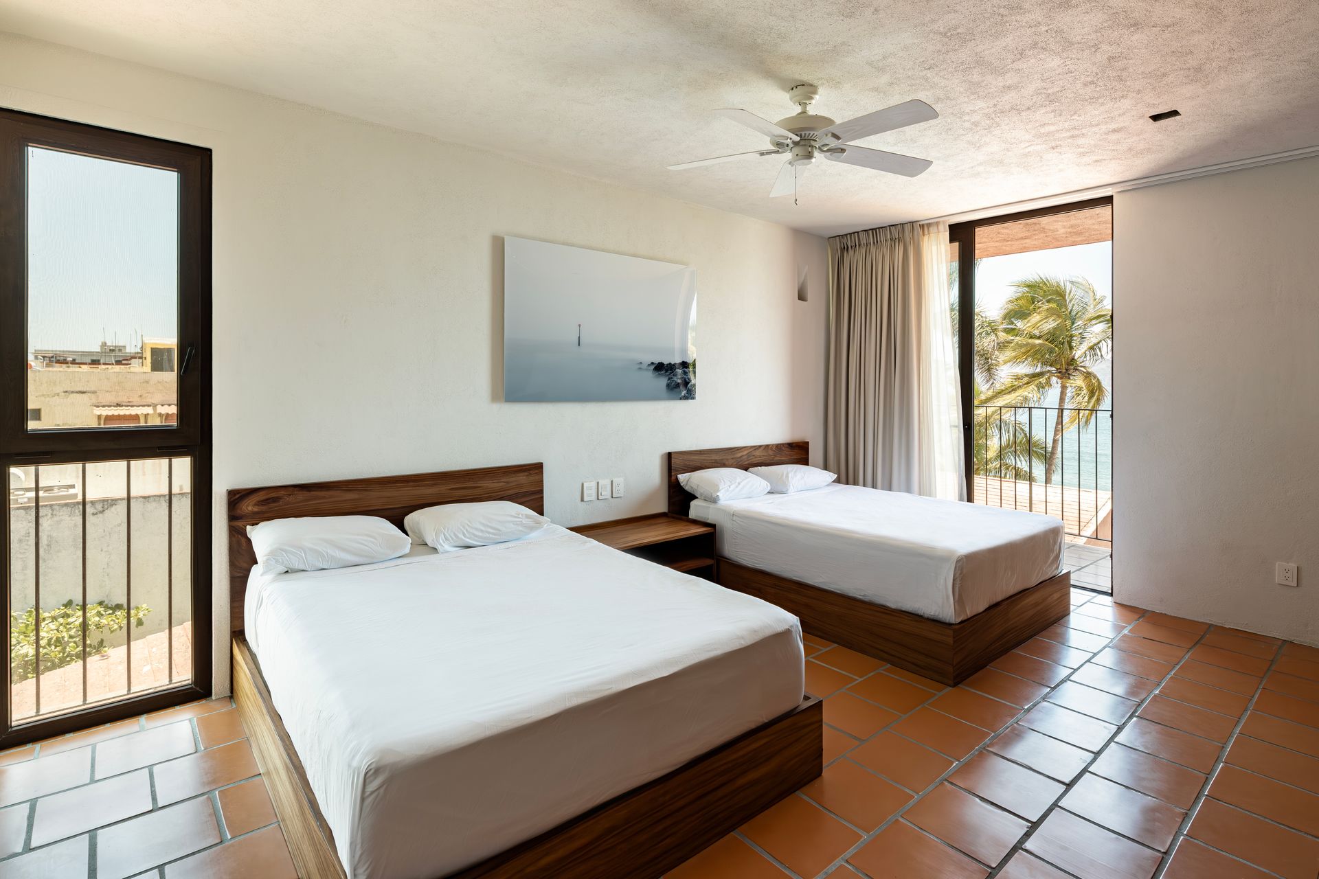 A hotel room with two beds and a ceiling fan
