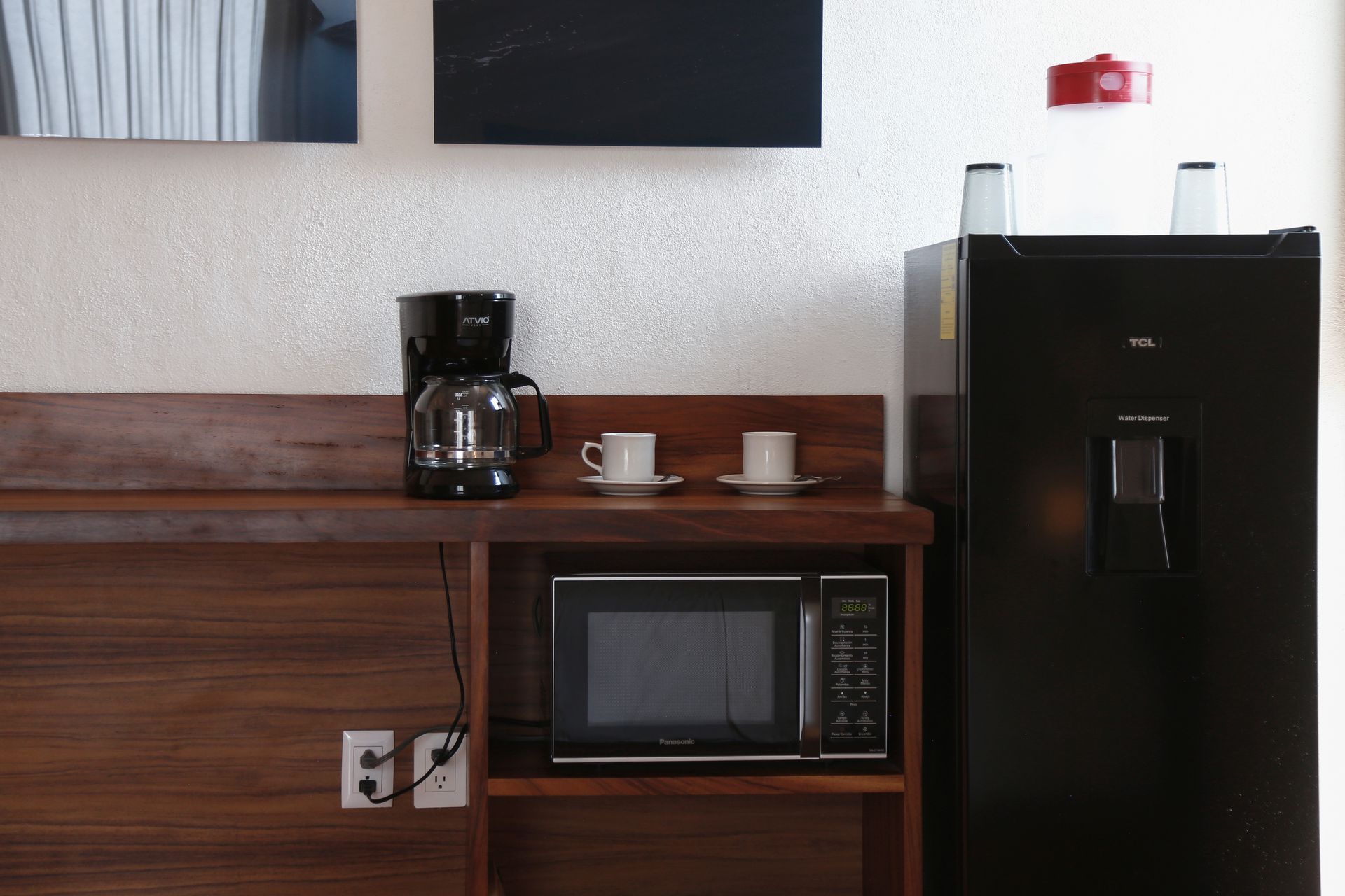A kitchen with a microwave , coffee maker , and refrigerator.