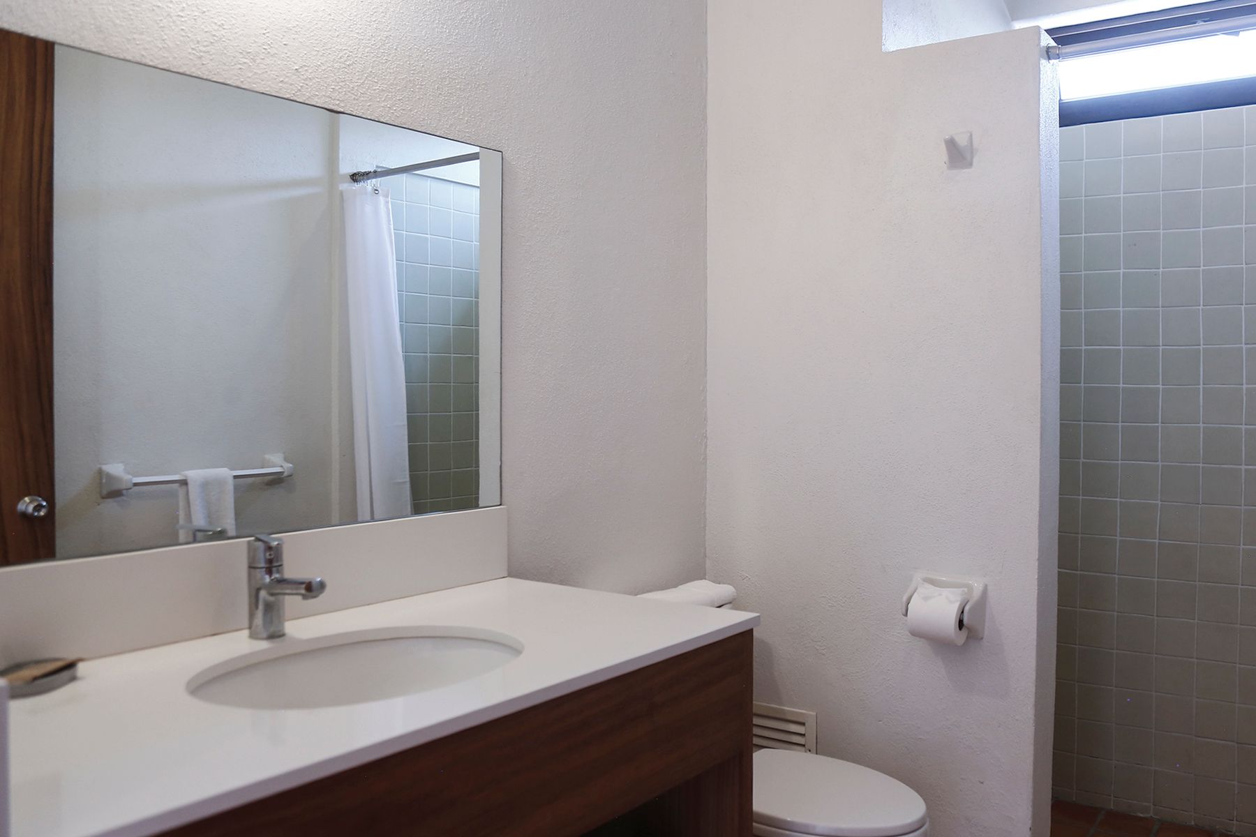 A bathroom with a sink , toilet and shower.