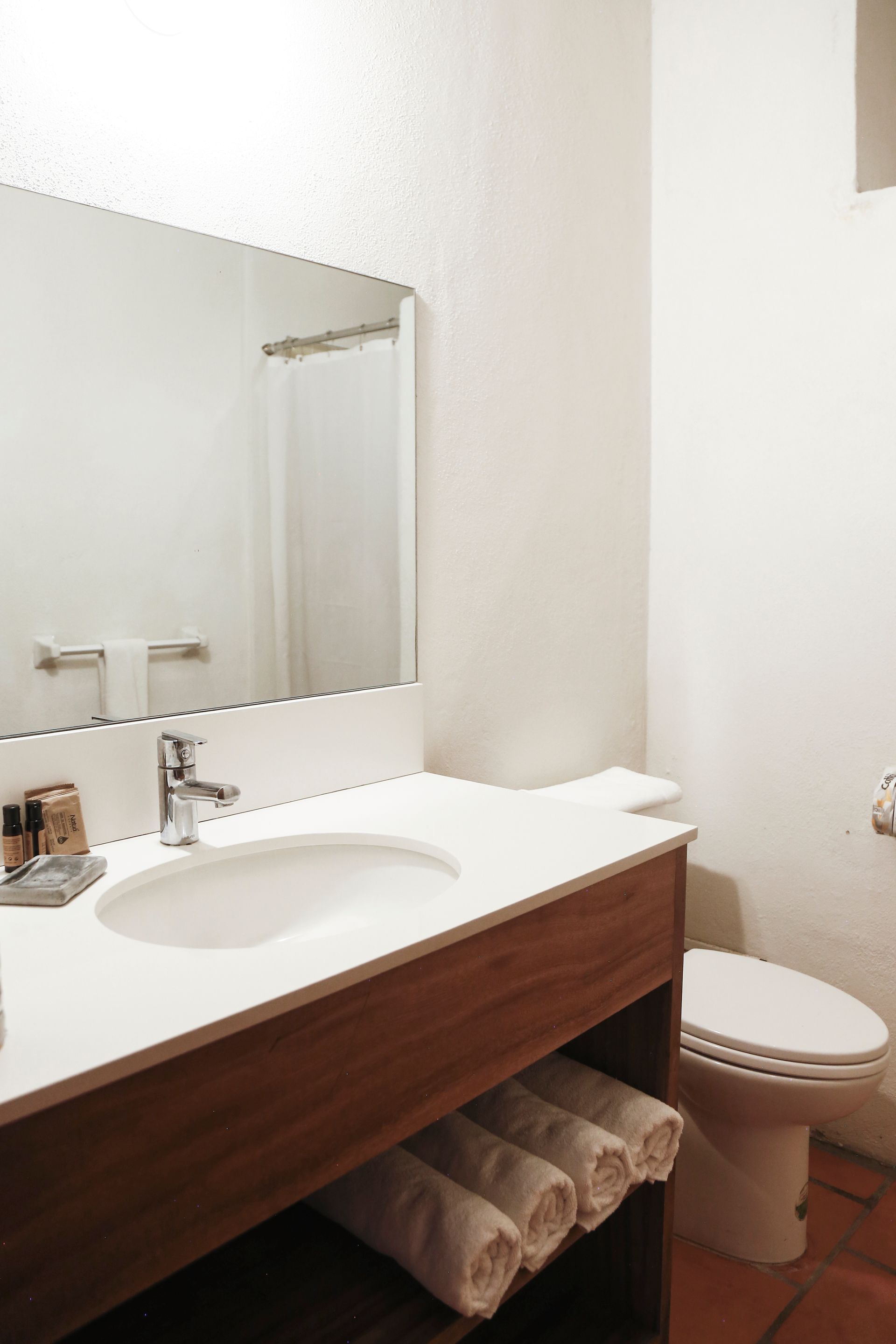 A bathroom with a sink , toilet and mirror