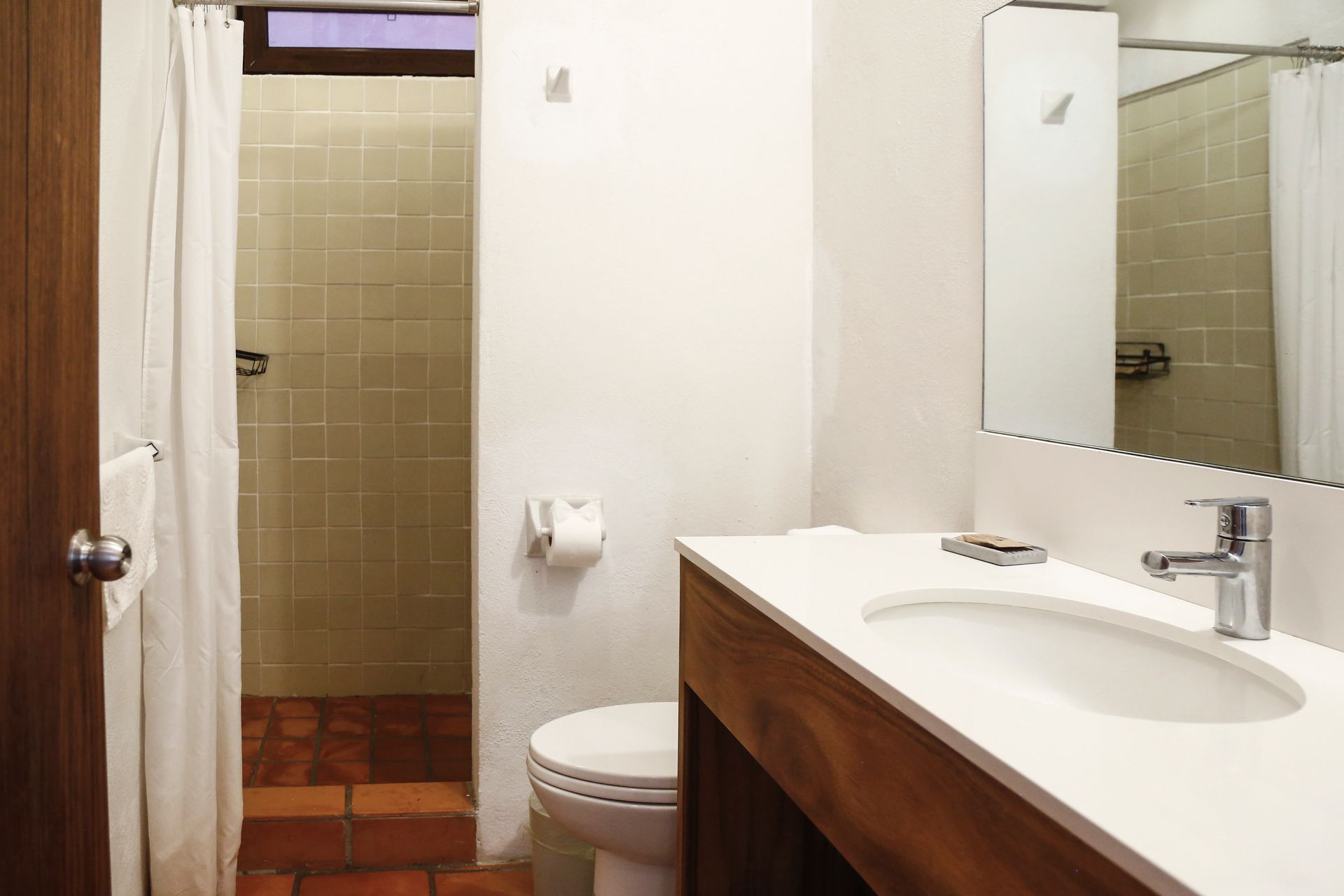 A bathroom with a toilet , sink and shower.