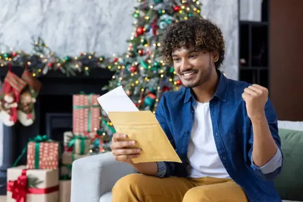 Seasonal worker celebrating a holiday job offer at home, highlighting CO seasonal employee rights.