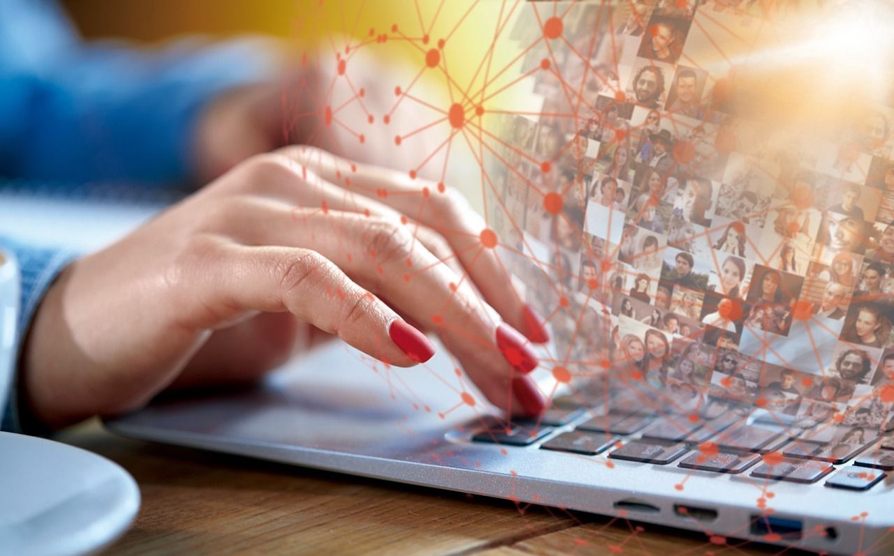 AI-powered hiring tools and legal considerations for avoiding bias in Colorado recruitment. Close-up of hands typing on a laptop with a digital network overlay and candidate profile images, symbolizing AI-powered hiring and recruitment screening in Colorado.