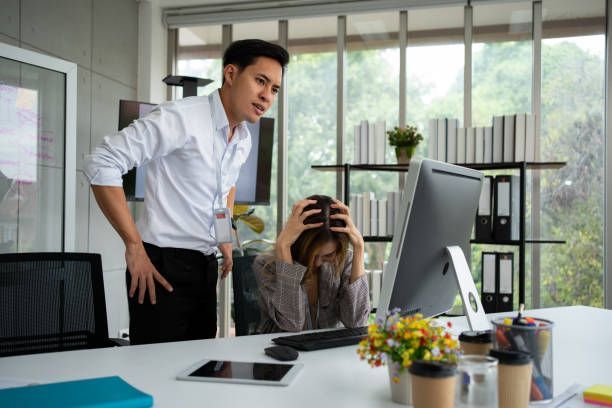 Supervisor confronting a distressed employee at her desk, representing workplace retaliation in Colorado and the importance of employee protection law